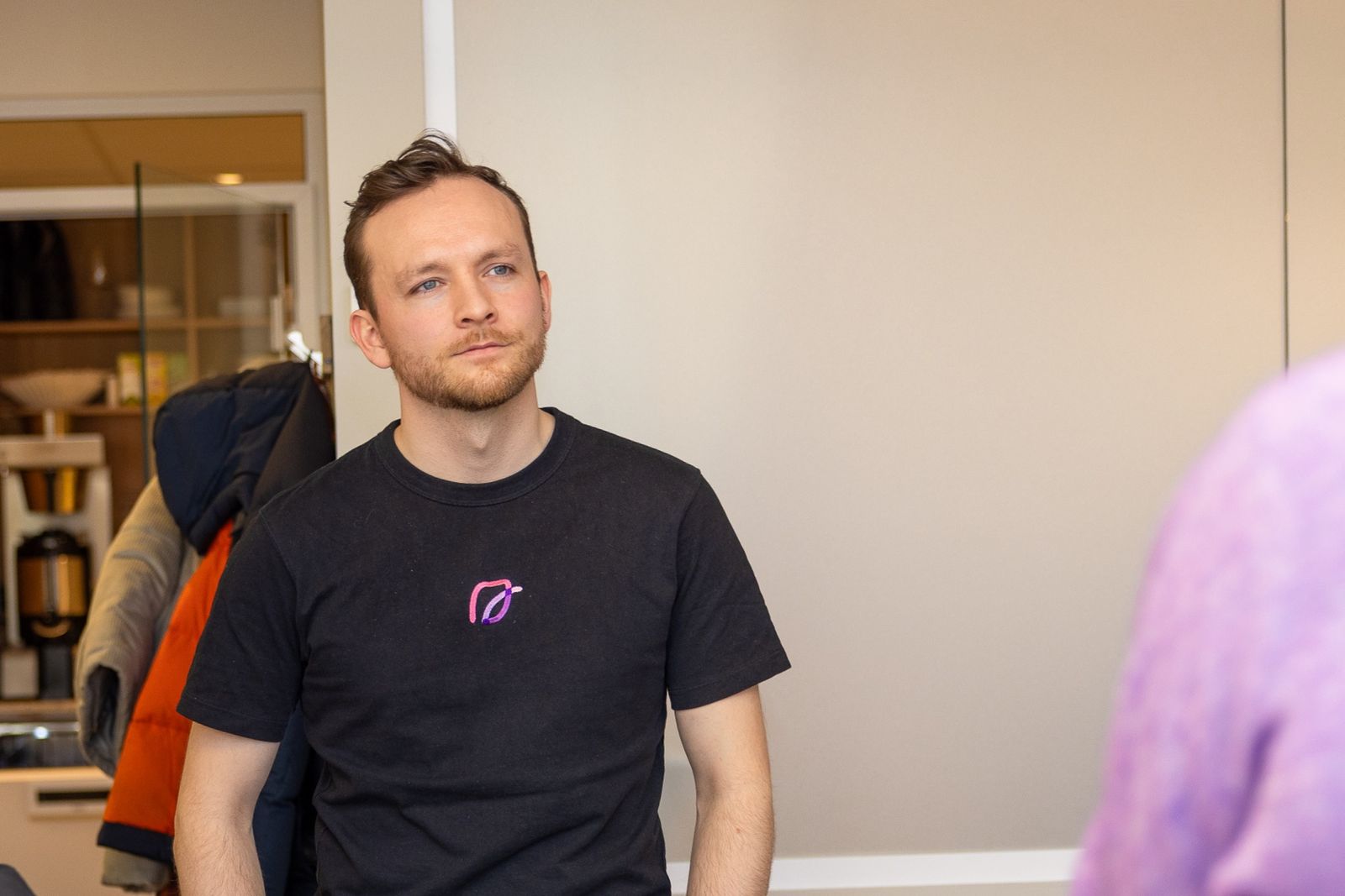Portret van een van de Cobrief-oprichters in zwart t-shirt met Cobrief-logo